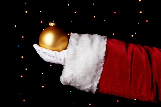 Santa Claus hand holding Christmas ball sur fond clair