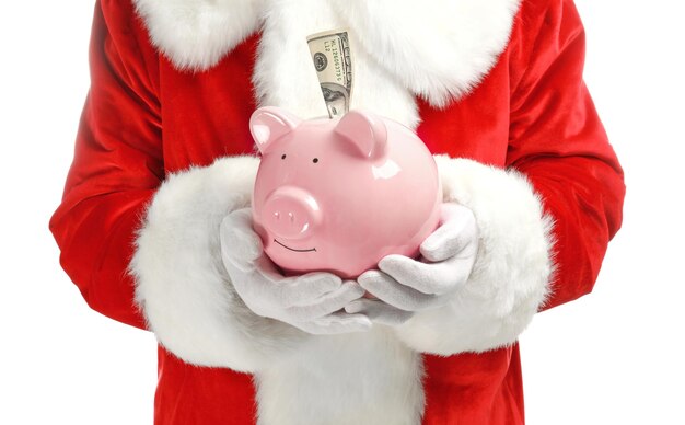 Santa Claus holding piggy bank avec billet sur fond blanc