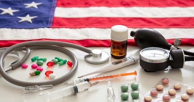 Photo santé américaine instruments médicaux et pilules sur une vue rapprochée du drapeau américain