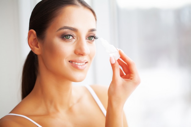 Santé et beauté. Soin des yeux. Belle jeune femme tenant des gouttes pour les yeux.