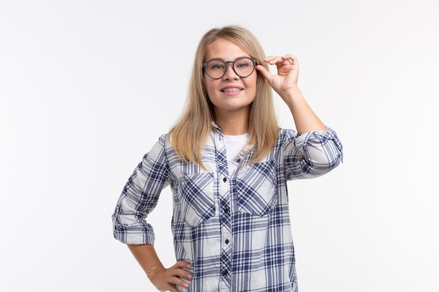 Santé des dents, dentisterie et correction de la morsure - Bonne femme souriante dans des verres avec des accolades sur blanc