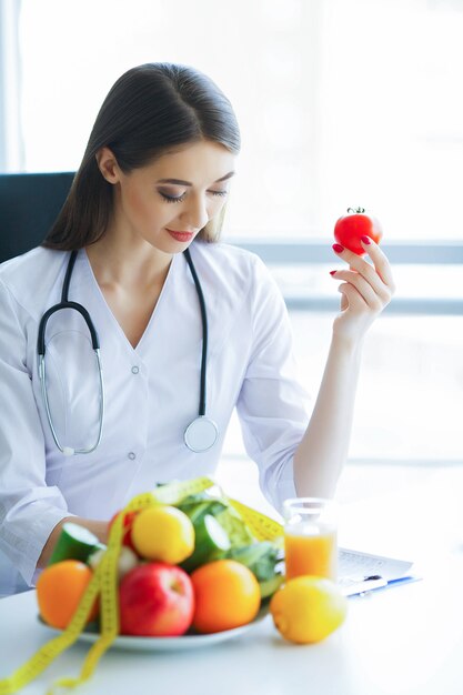 Photo santé. régime alimentaire et en bonne santé. docteur diététiste tenant une tomate fraîche