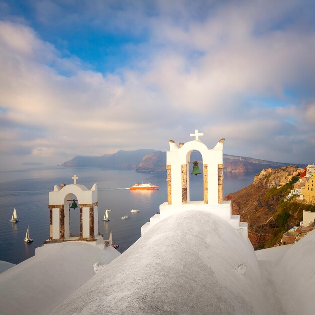 Santorin Grèce Arche de cloche blanche et vue sur la mer bleue avec des bateaux Composition conceptuelle de la célèbre architecture de l'île de Santorin Île de Santorin Grèce Europe