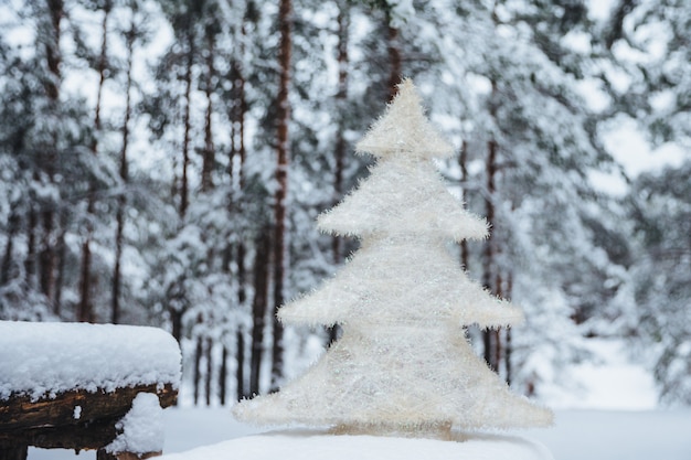 sapin artificiel blanc sur un banc recouvert de neige