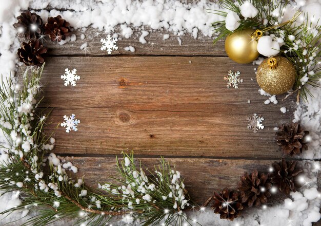 Sapin de neige avec des cônes et des décorations de Noël sur l'espace de copie de fond en bois