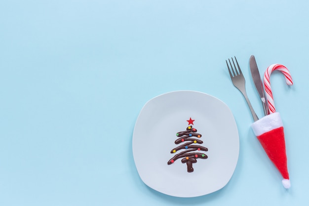 Sapin de Noël au chocolat sucré sur assiette et couverts