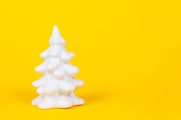 Sapin de Noël blanc sur fond jaune vif.