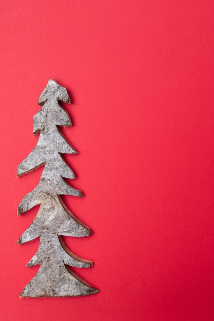 Sapin de Noël en bois sur fond rouge. Carte de Noël.