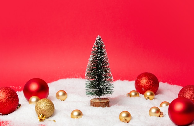 Sapin de Noël avec des boules et de la neige autour