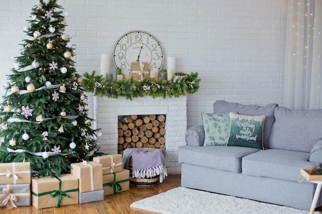 Sapin de Noël et canapé gris près de la cheminée