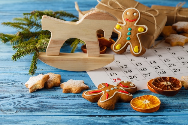 Sapin de Noël, coffret cadeau et biscuits de vacances avec décoration sur table avec calendrier