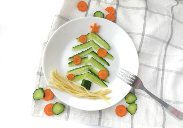 Sapin de Noël comestible amusant composé de concombres et de carottes, idée de petit-déjeuner pour les enfants.