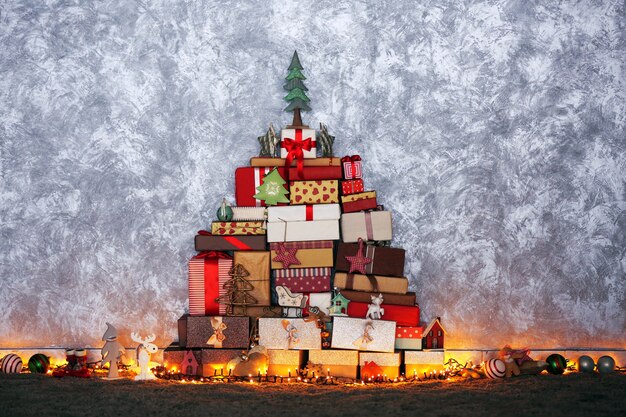Sapin de Noël composé de boîtes à cadeaux et d'autres décorations au sol