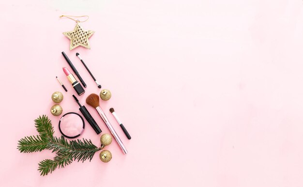 Sapin de Noël cosmétique de maquillage sur fond rose