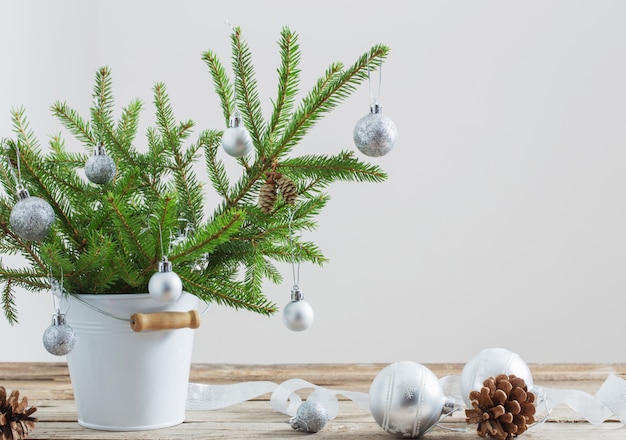 Sapin de Noël dans un seau sur une vieille table en bois