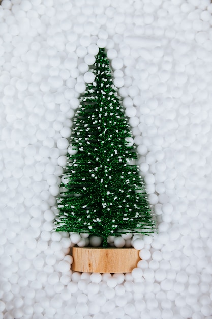 Photo sapin de noël en décoration de boules de neige blanches. mise à plat. concept minimal du nouvel an.