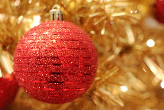 Sapin de Noël avec décoration, boules rouges et éclairage.