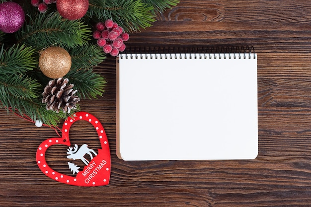 Sapin de Noël avec décoration et note vide sur planche de bois marron