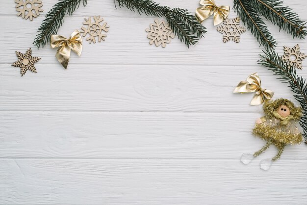 Sapin de Noël avec décoration et paillettes sur fond en bois.