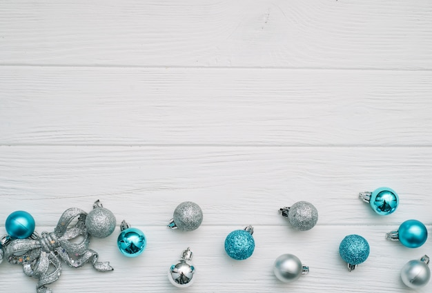 Sapin de Noël avec décoration et paillettes sur fond en bois.