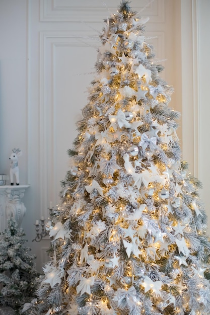 Sapin de Noël avec décorations blanches et argentées coffrets cadeaux et guirlande lumineuse Concept de Noël blanc Maison confortable avec décorations de Noël