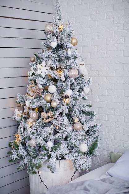 Sapin de Noël avec des décorations dorées et blanches