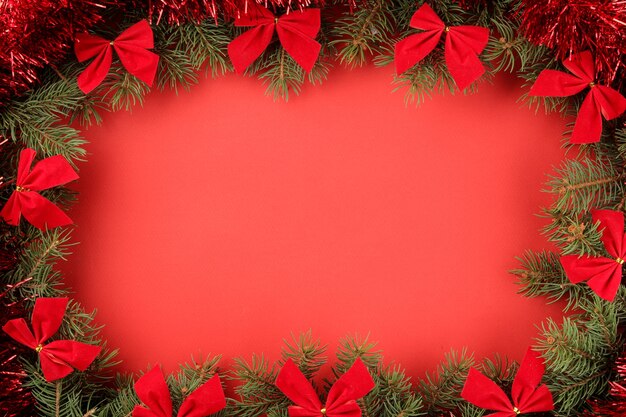 Sapin de Noël et décorations de Noël colorées sur fond rouge clair
