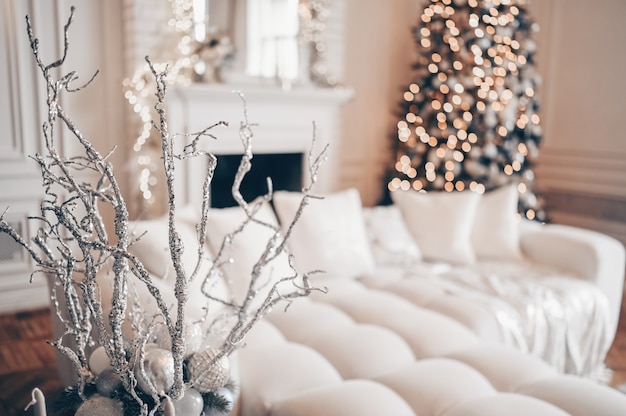 Sapin de Noël décoré avec des cadeaux en blanc classique