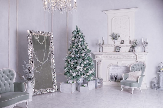 Sapin de Noël décoré et coffrets cadeaux dans le salon blanc mobilier vintage de salon