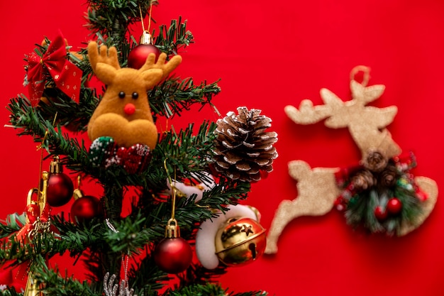 Sapin de Noël décoré sur fond rouge.