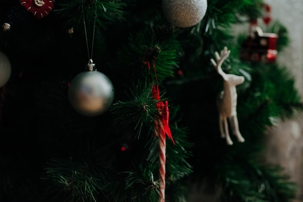 Sapin de Noël décoré d'une guirlande et de jouets de Noël. Fermer.