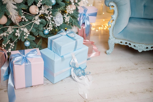 Le sapin de Noël est décoré de jouets et de guirlandes avec des cadeaux en dessous Cadeaux de Noël sous le sapin