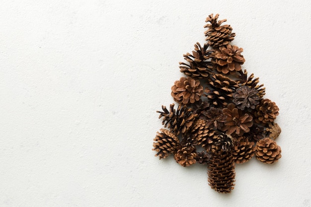 Sapin de Noël fabriqué à partir de cônes naturels sur fond coloré Vue d'en haut Concept minimal du Nouvel An avec espace de copie