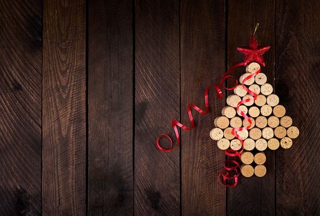 Sapin de Noël fait de bouchons de vin sur fond en bois. Carte postale maquette avec arbre de Noël et espace de copie pour le texte. Vue de dessus.