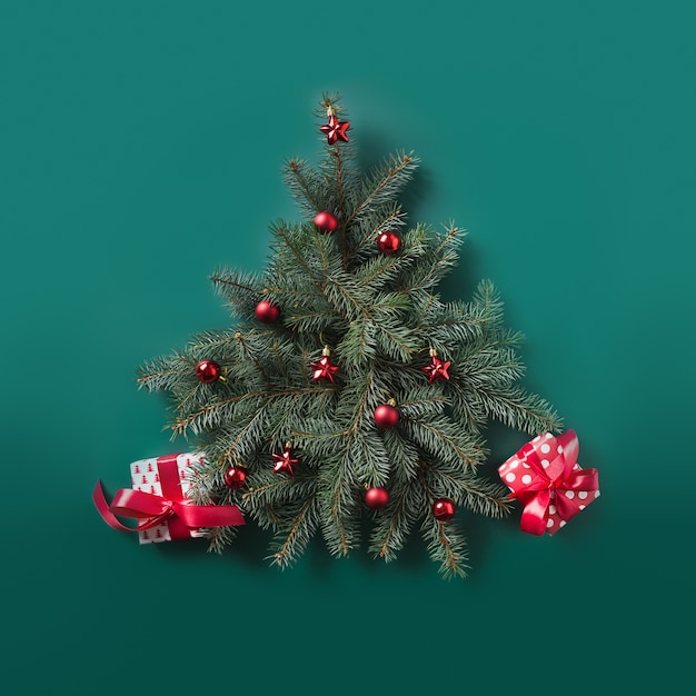 Sapin de Noël fait de branches de sapin et de boules rouges avec des cadeaux rouges décorés