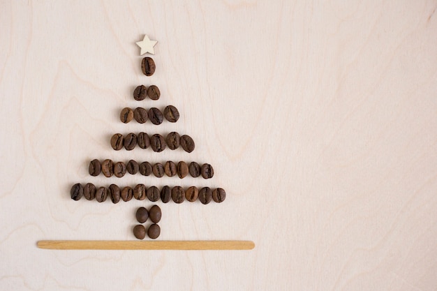 Sapin de Noël fait de grains de café sur fond en bois