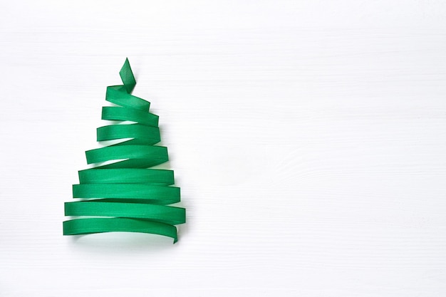 Sapin de Noël fait de ruban vert sur fond blanc. Espace de copie