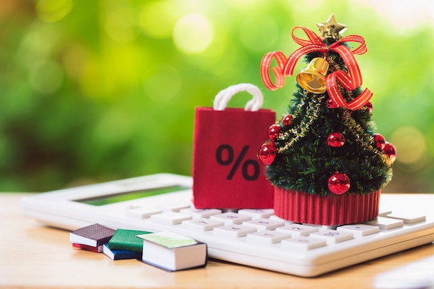 Un sapin de Noël joliment décoré placé sur une calculatrice blanche