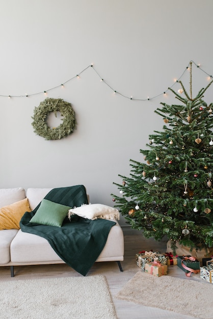 Un sapin de Noël avec des jouets et un canapé avec des coussins à l'intérieur du salon