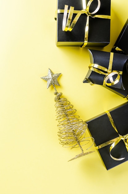 Sapin de Noël or et cadeaux sur fond jaune