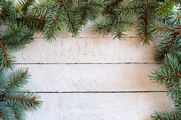 Sapin de Noël sur une planche de bois blanche avec espace copie, cadre d'hiver