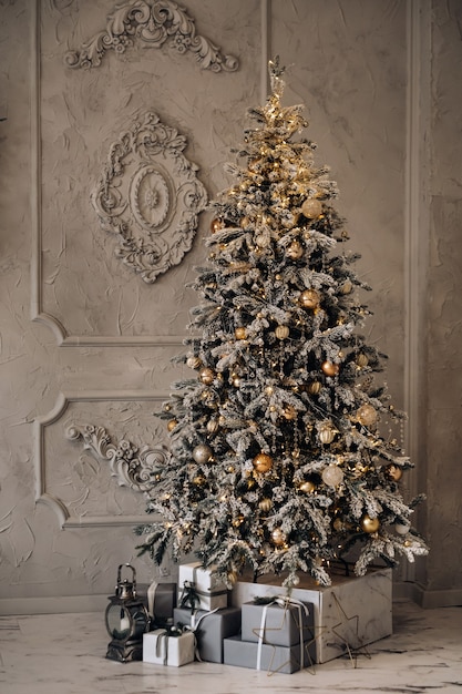 Sapin de Noël pleine longueur. Le soir du Nouvel An, un sapin de Noël enneigé se dresse à la maison