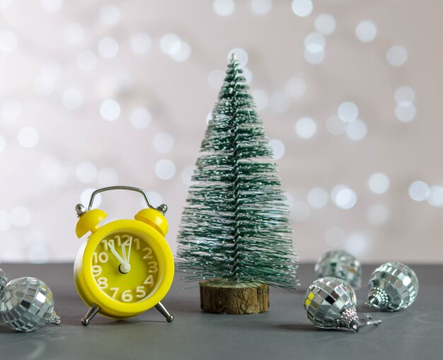 Sapin de Noël, réveil jaune et boules à facettes sur la table