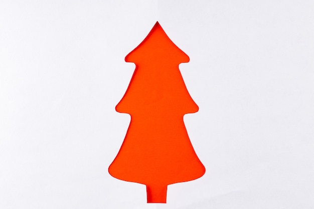 Photo sapin de noël rouge sur fond blanc. sapin de noël en papier rouge. décoration de noël