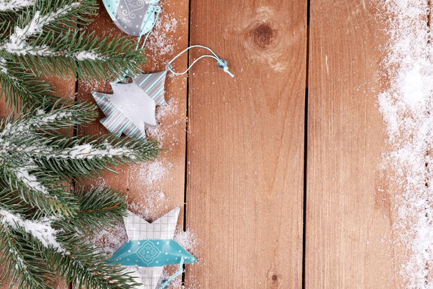 Sapin vert avec des jouets et de la neige sur fond de bois