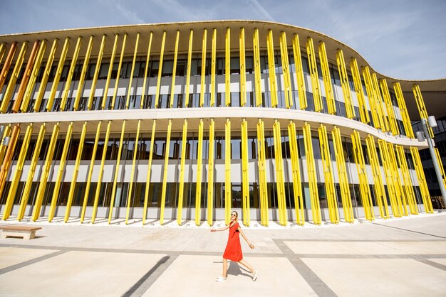 SARAGOSSE, ESPAGNE - 21 août 2017 : Femme en robe rouge marchant près du pavillon du bâtiment moderne de l'Expo 2008, exposition internationale tenue à Saragosse, Espagne