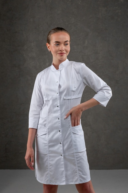 Saratov Russie 7202022 Vêtements médicaux blancs sur le modèle fille Concept vestimentaire pour médecin et infirmière sur fond neutre gris foncé