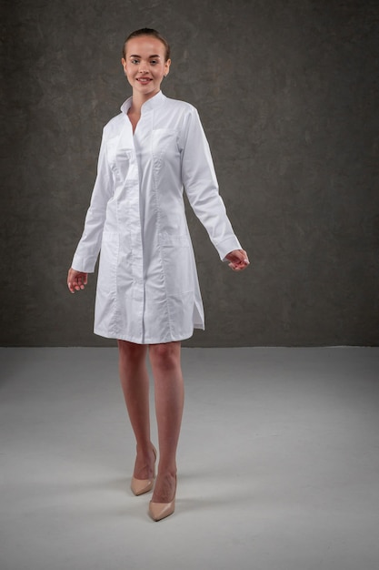 Saratov Russie 7202022 Vêtements médicaux blancs sur le modèle fille Concept vestimentaire pour médecin et infirmière sur fond neutre gris foncé