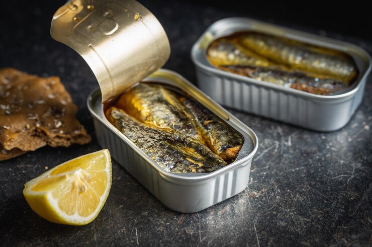 Photo sardines en conserve poisson de mer en boîte de conserve sur tableau noir