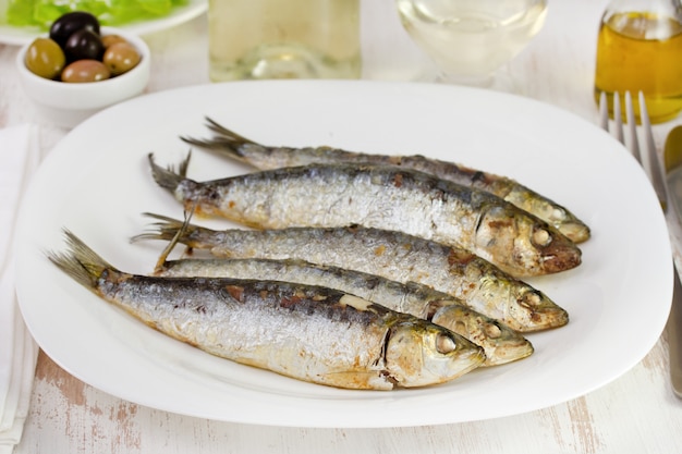 Sardines frites sur la plaque blanche